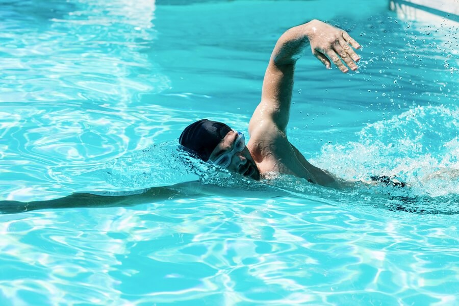 Un nageur dans une piscine qui fait du crawl