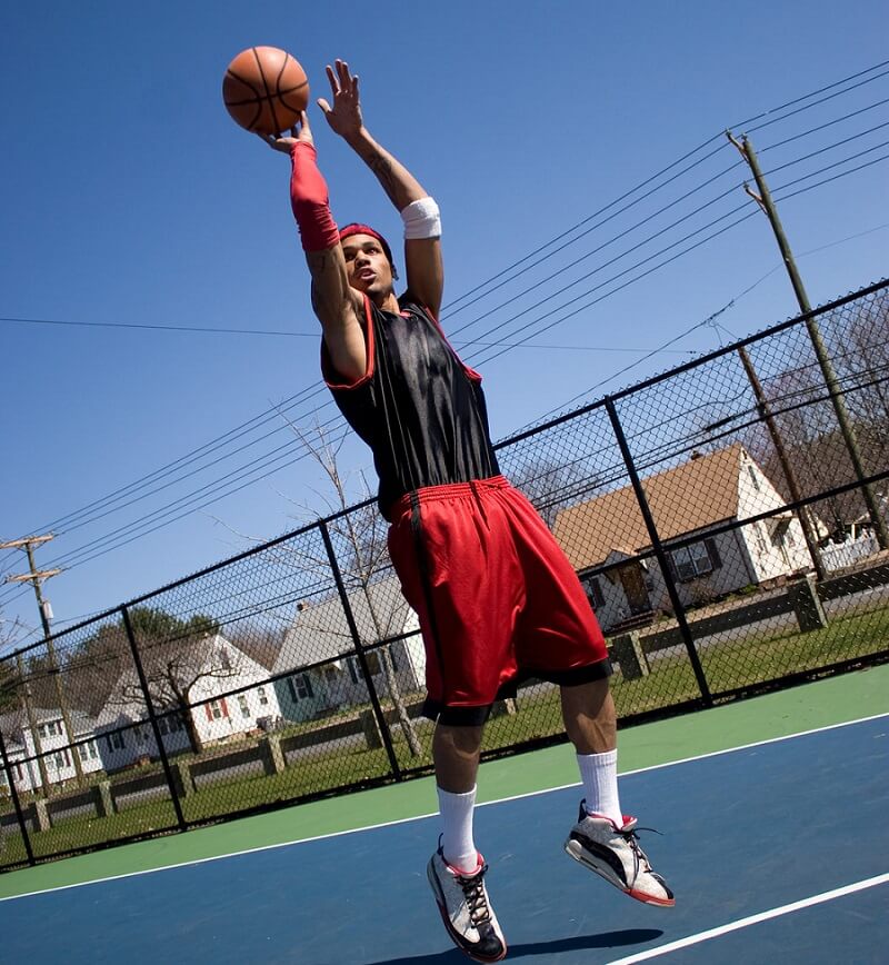 Un meneur basket qui fait un smash